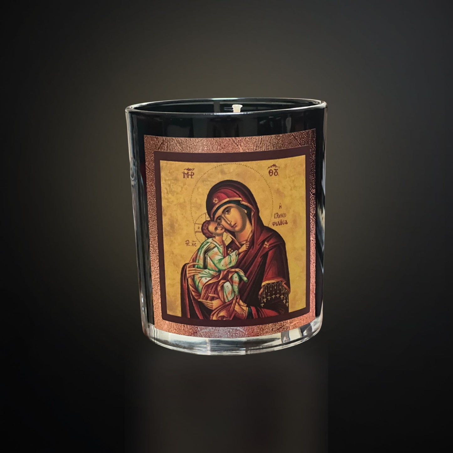 “Black Livani candle with Mary icon on a dark gradient background with soft warm lighting.”