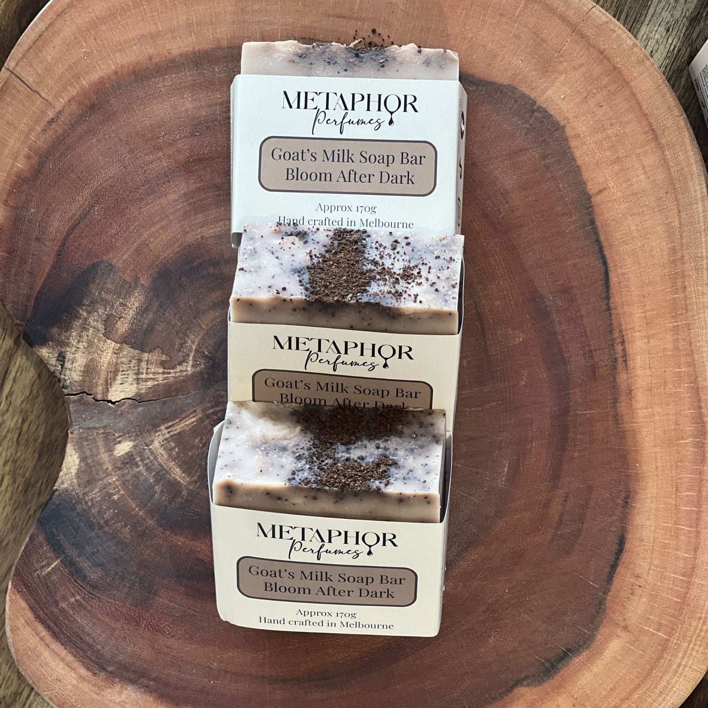 Product image of Metaphor Perfumes goat’s milk soap bar on a wooden surface — Bloom After Dark, inspired by YSL Black Opium.