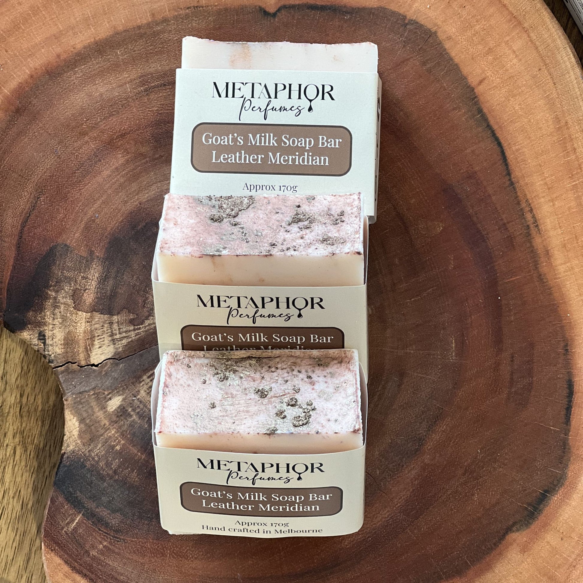 Product image of Metaphor Perfumes goat’s milk soap bar on a wooden surface — Leather Meridian, inspired by Tom Ford Ombre Leather.
