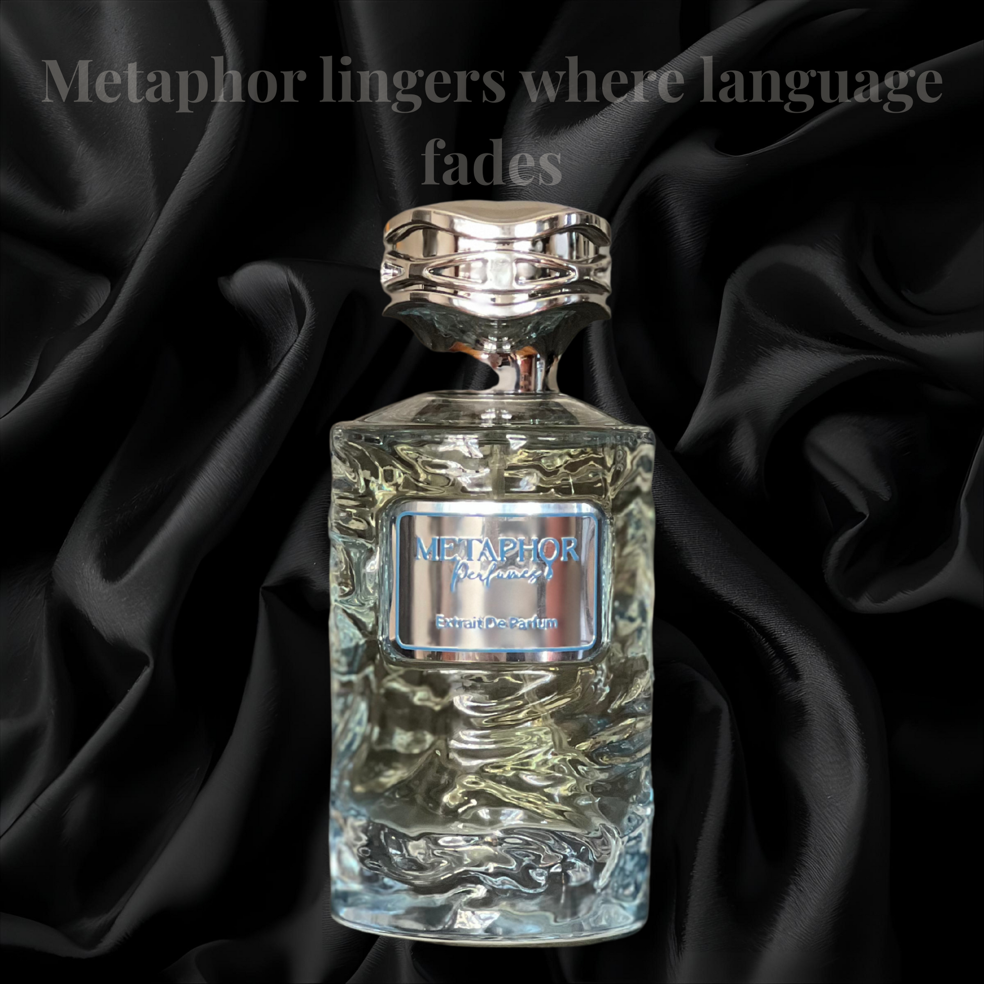 “Metaphor Eau de Parfum bottle resting against black satin folds, with the quote ‘Metaphor lingers where language fades’ above. The bottle features cool blue tones and a metallic cap, evoking emotional clarity, stillness, and poetic depth.”