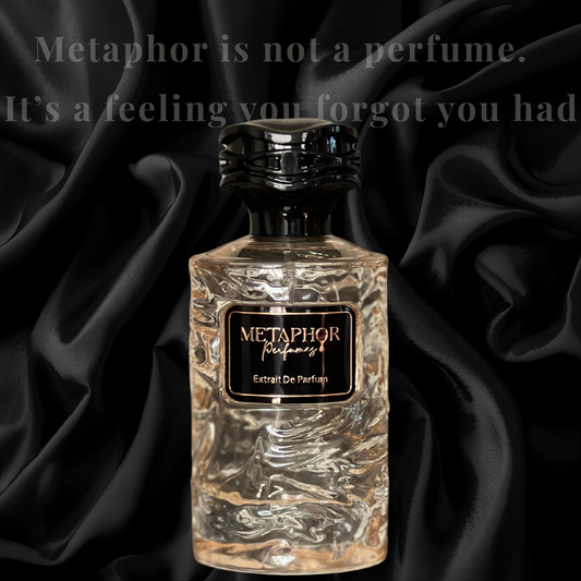 “Metaphor Extrait De Parfum bottle resting against black satin folds, with the quote ‘Metaphor is not a perfume. It’s a feeling you forgot you had’ above. The image evokes luxury, memory, and emotional depth.”