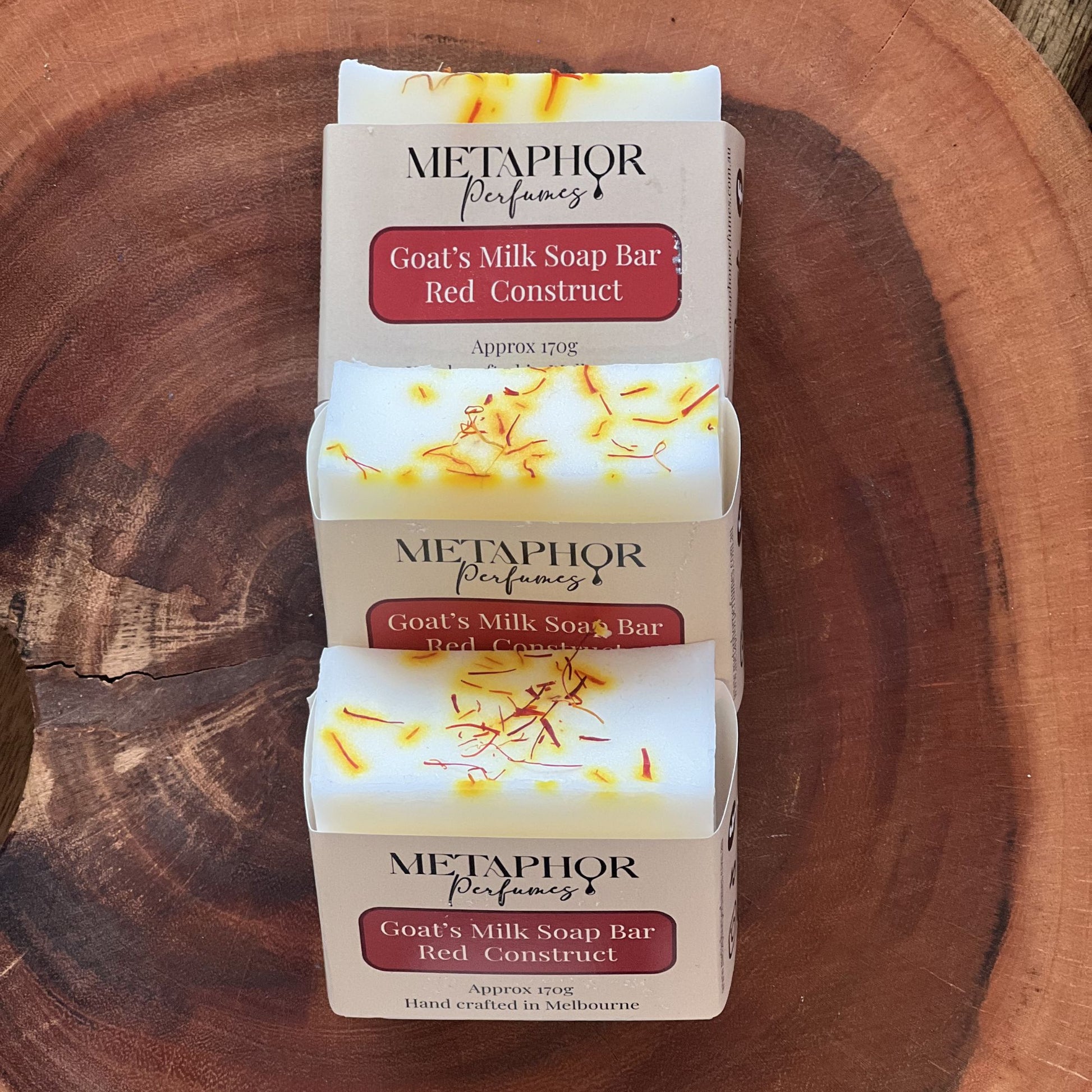 Product image of Metaphor Perfumes goat’s milk soap bar on a wooden surface — Red Construct, inspired by MFK Baccarat Rouge 540.