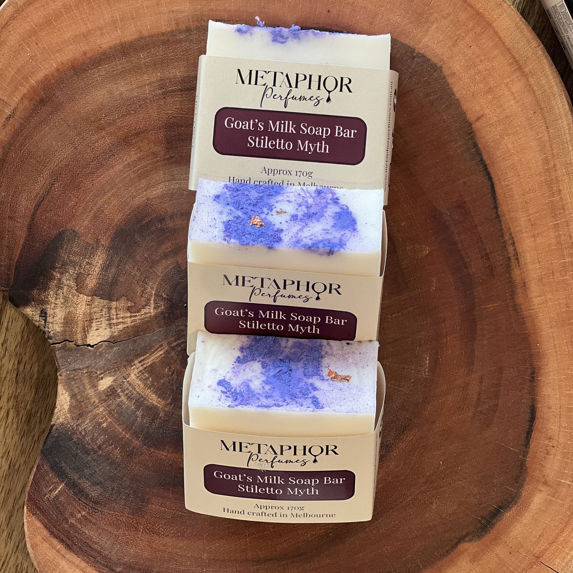 Product image of Metaphor Perfumes goat’s milk soap bar on a wooden surface — Stiletto Myth, inspired by Carolina Herrera Good Girl.