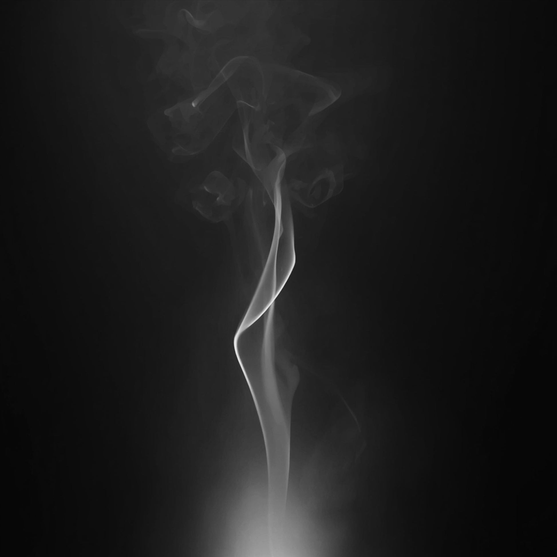 A white Livani candle hero image with soft rising smoke against a dark background.