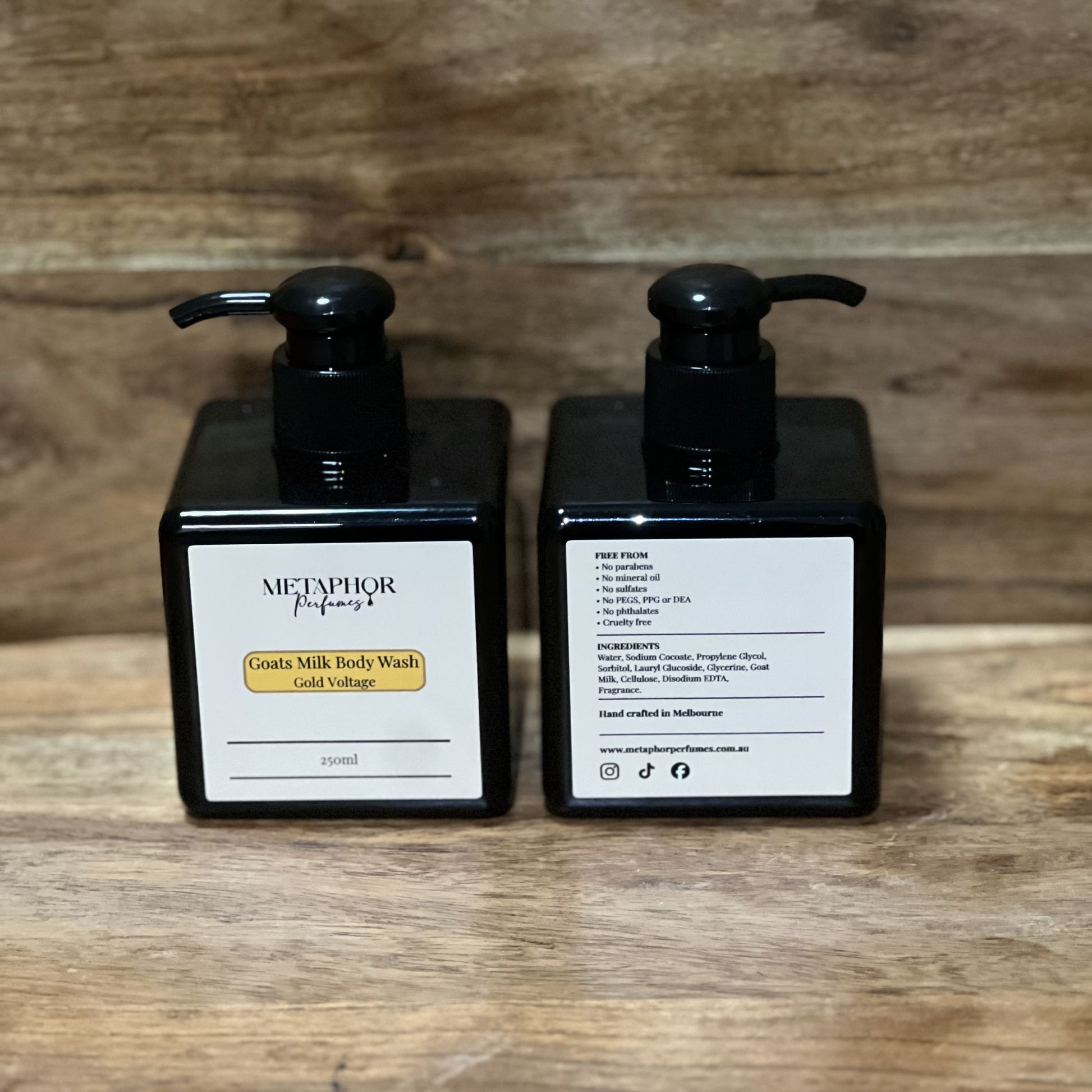 Product image of Metaphor Perfumes goats milk body wash in a black pump bottle on a wooden surface — Gold Voltage, inspired by Paco Rabanne 1 Million.