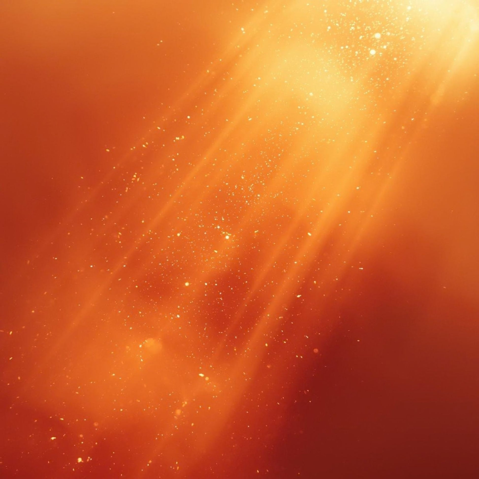 A radiant red‑gold beam of light cutting diagonally through warm amber haze, scattered with fine silver crystalline shimmer — an atmospheric visual representing a reinterpretation of Maison Francis Kurkdjian Baccarat Rouge 540.