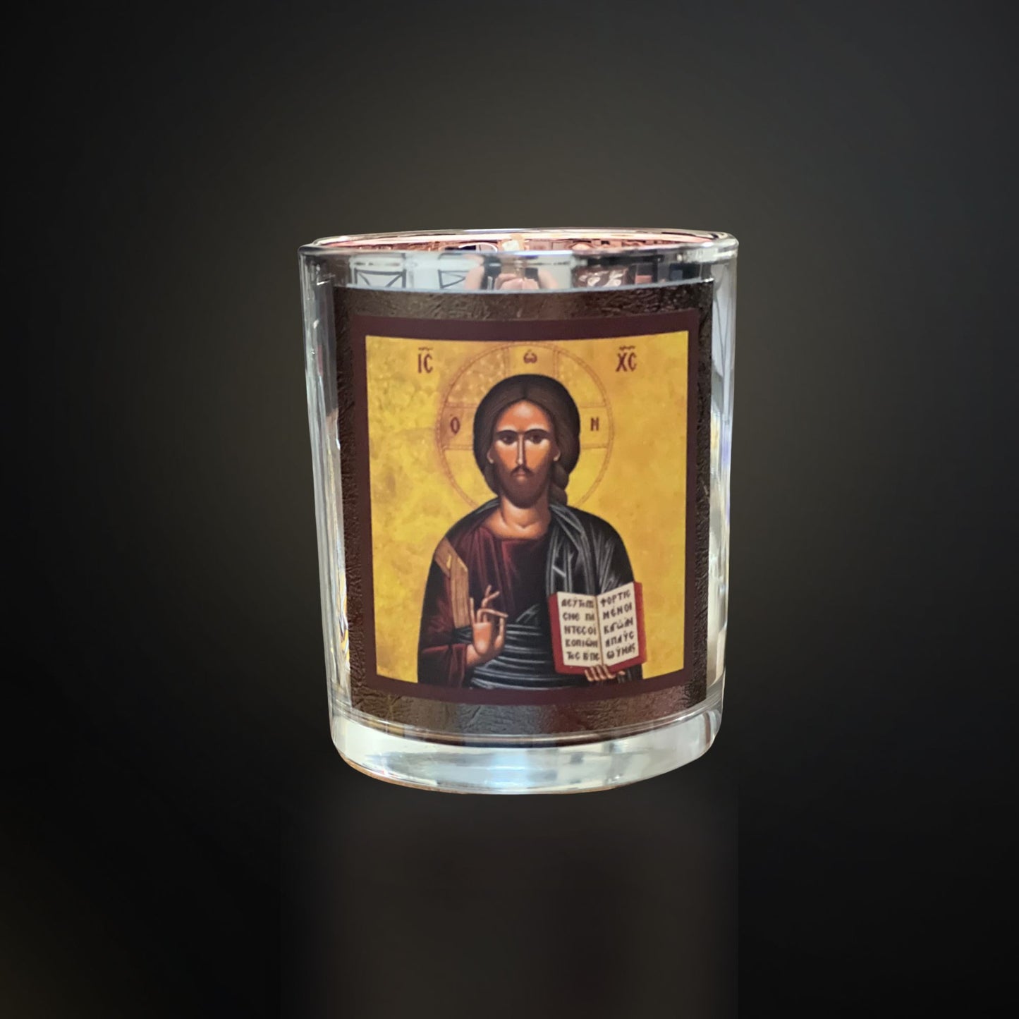 Silver Livani candle with Christ icon on a dark gradient background with soft cool lighting.