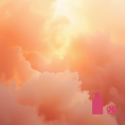 Soft orange‑pink clouds with warm glowing light, with a small magenta pump‑bottle icon and a magenta loofah icon in the lower right corner.